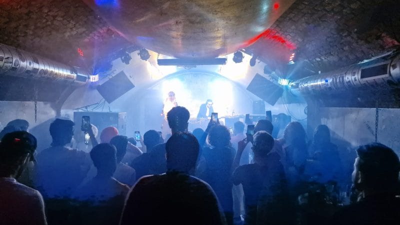 Party im Club-Kellergewölbe vom Weberknecht Wien mit tanzenden Gästen und DJ auf der Bühne