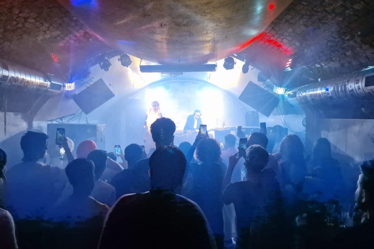 Party im Club-Kellergewölbe vom Weberknecht Wien mit tanzenden Gästen und DJ auf der Bühne