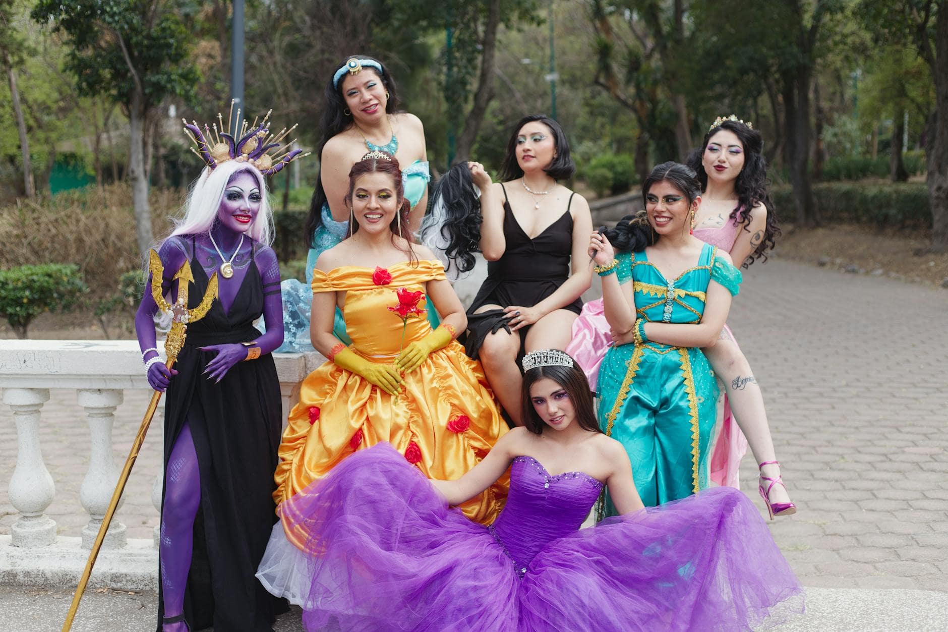 A cheerful group of women in fantasy costumes posing outdoors, exuding vibrant colors and playful energy.