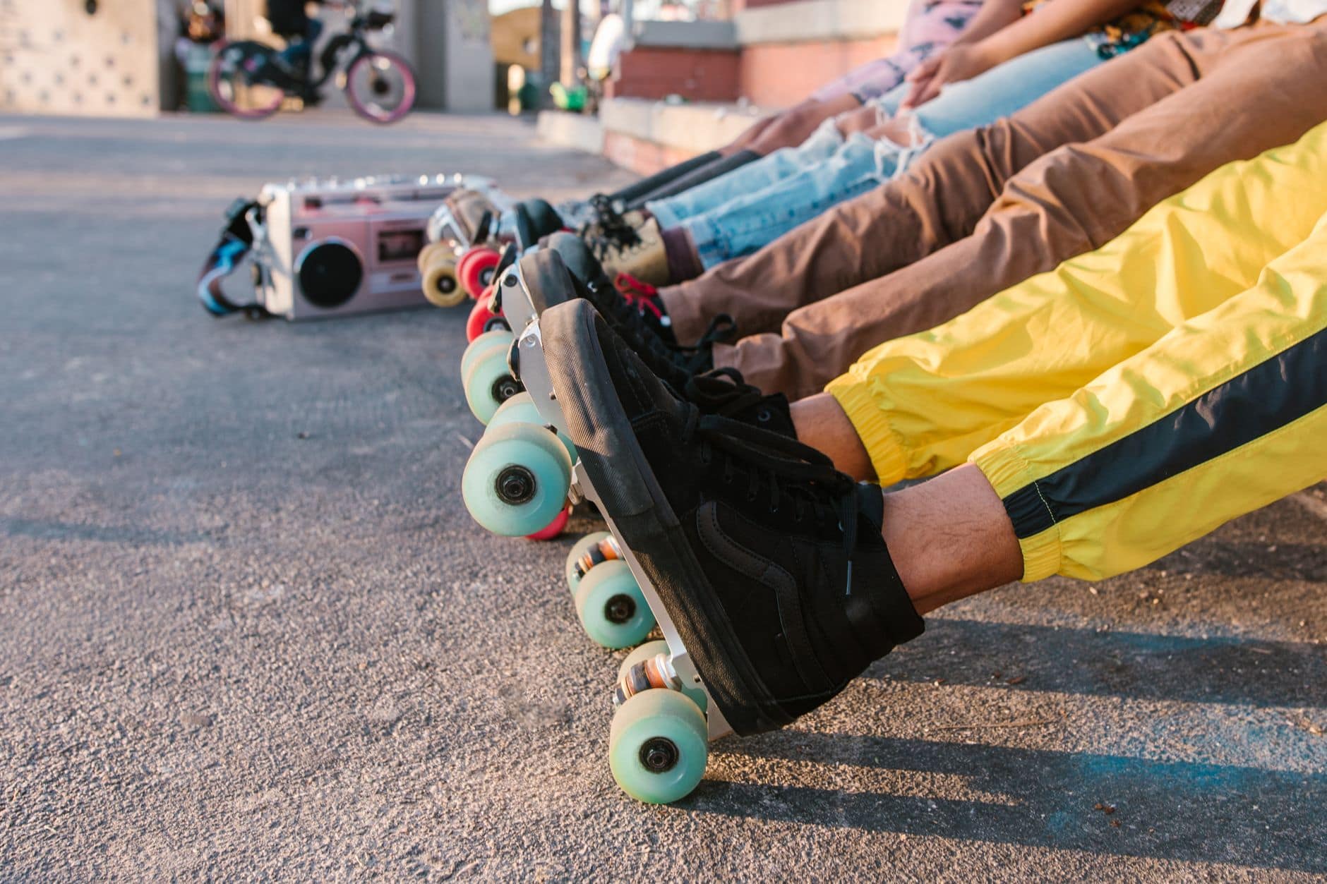 A group of friends relaxing in line with vibrant roller skates at an outdoor skatepark.